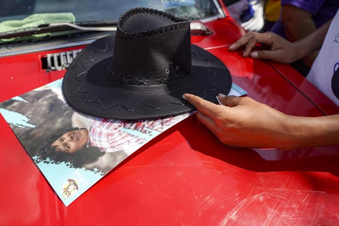Archivo - Arquivo - 22 de março de 2022, San Salvador, El Salvador: Um manifestante coloca seu chapéu em uma placa da ativista ambiental assassinada Berta Cáceres, morta em Honduras em 2016, durante um protesto pelo reconhecimento da água como um direito 