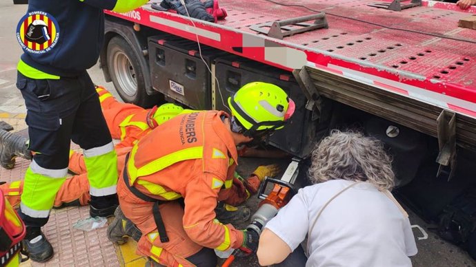 Bomberos trabajan en la extracción de una persona que quedó atrapada bajo un camión grúa en Cullera (Valencia)