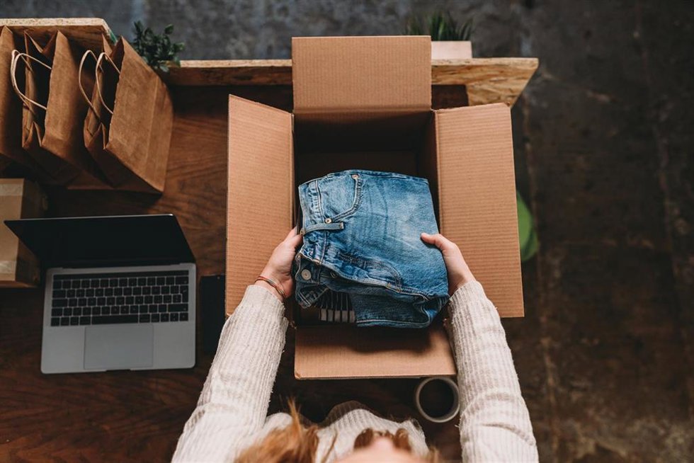 Archivo - A millennial woman is preparing the shipment of some clothes in her new online shop. She's the owner of an online thrift store. New small business concept.