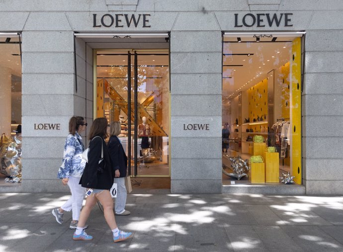 Archivo - Varias personas pasan por una tienda de Loewe, en la milla de oro de Madrid, a 3 de mayo de 2024, en Madrid (España).