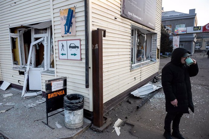 February 12, 2025, Kyiv, Ukraine: KYIV, UKRAINE - FEBRUARY 12, 2025 - A man drinks from a cup outside a building in the Obolonskyi district damaged by a Russian ballistic missile strike, Kyiv, capital of Ukraine. Early on Wednesday, February 12, Russia la