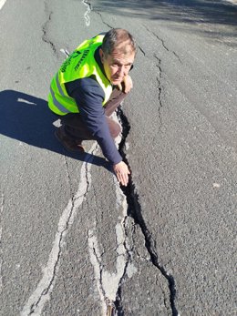El diputado provincial del PP Nicolás Grimaldos señala una grieta en la vía de acceso a Segura de la Sierra, de titularidad de la Diputación.