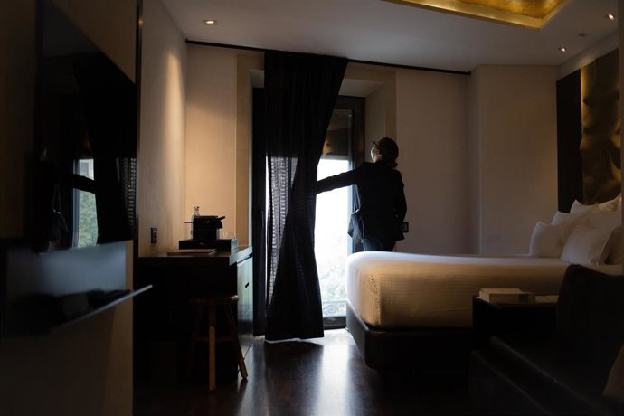 Archivo - Una camarera de pisos limpia una de las habitaciones de un hotel.