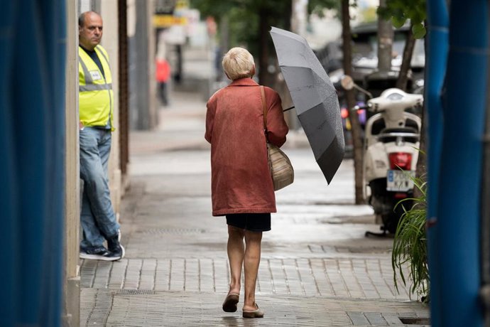 Archivo - Una mujer pasea por una calle con un paraguas, a 21 de mayo de 2023, en Madrid (España). La Agencia Estatal de Metereología (Aemet) ha activado el aviso por tormentas, precipitaciones y los fenómenos costeros en ocho provincias por la entrada de