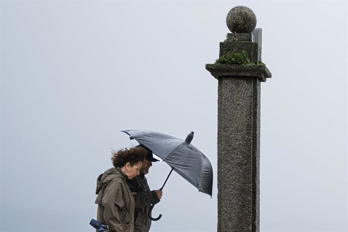 Dos personas se refugian de la lluvia con paraguas en la comarca de Salnés, a 27 de enero de 2025, en Salnés, Pontevedra, Galicia (España).