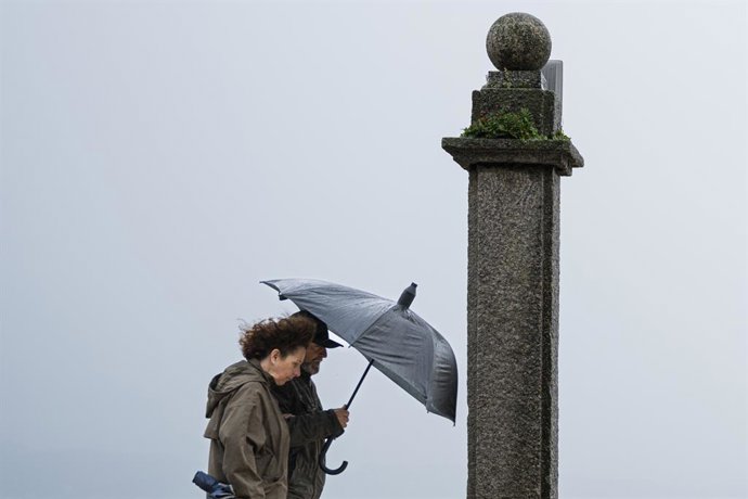 Dos personas se refugian de la lluvia con paraguas en la comarca de Salnés, a 27 de enero de 2025, en Salnés, Pontevedra, Galicia (España).