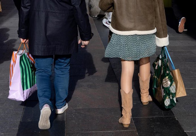 Archivo - Varias personas con bolsas durante las rebajas de enero 
