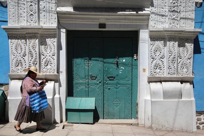 Archivo - 28 de maro de 2024, Potosi, Departamento de Potosí, Bolívia: Uma cholita caminha pela rua em frente  casa das trs portas (Casa de las Tres Portadas) enquanto consulta seu telefone em Potosí. Potosi depende da minerao de prata desde o sécu
