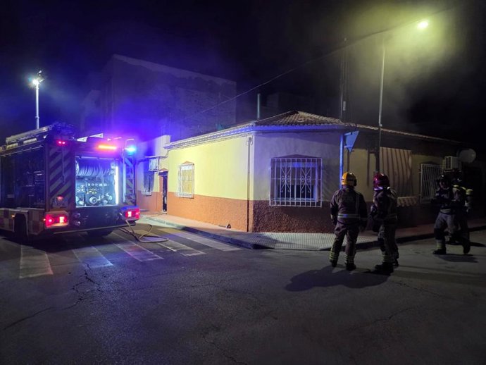 Bomberos junto a la vivienda incendiada