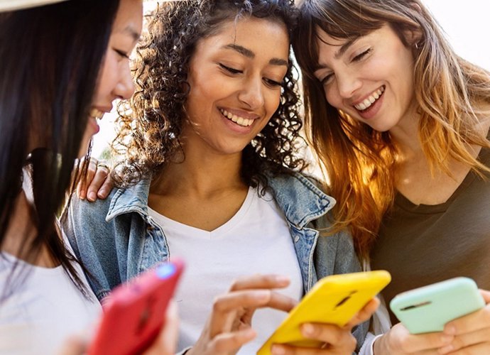 Tres mujeres usando el teléfono móvil