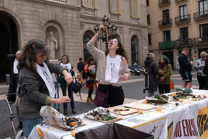 Una mujer come calçots durante una concentración de la Asamblea Pagesa y Ciudadana Metropolitana, en la plaza de Sant Jaume frente al Ayuntamiento de Barcelona