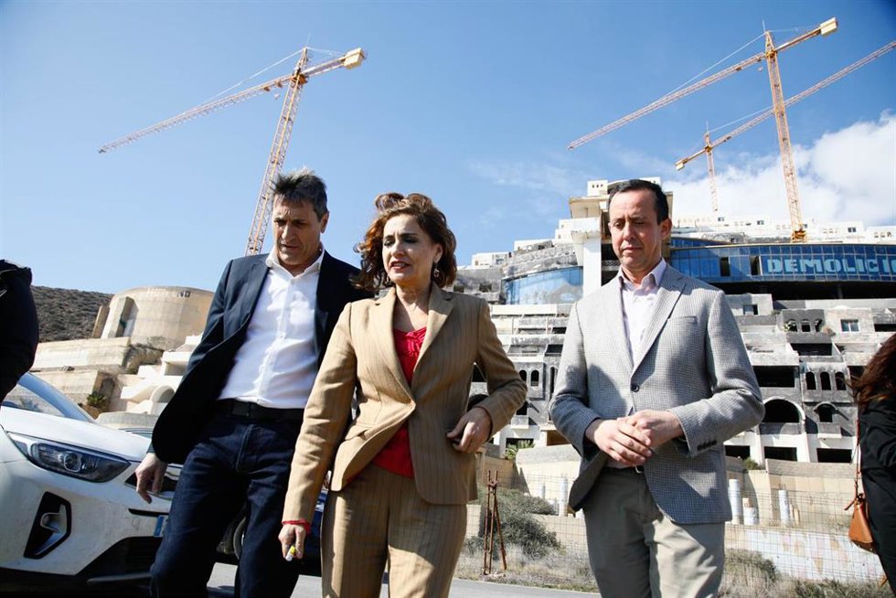 La vicepresidenta y ministra de Hacienda, María Jesús Montero, frente al hotel del paraje de El Algarrobico en Carboneras (Almería) junto al delegado de Gobierno en Andalucía, Pedro Fernández, y el subdelegado de Gobierno en Almería, José María Martín. 