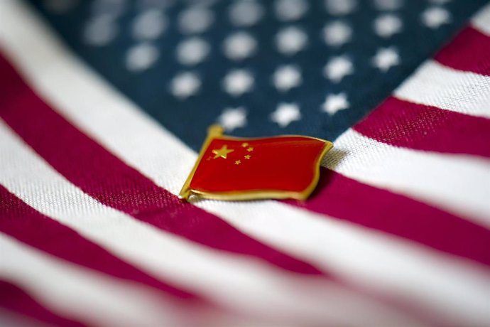 Archivo - Pin de una bandera de China sobre la de Estados Unidos.