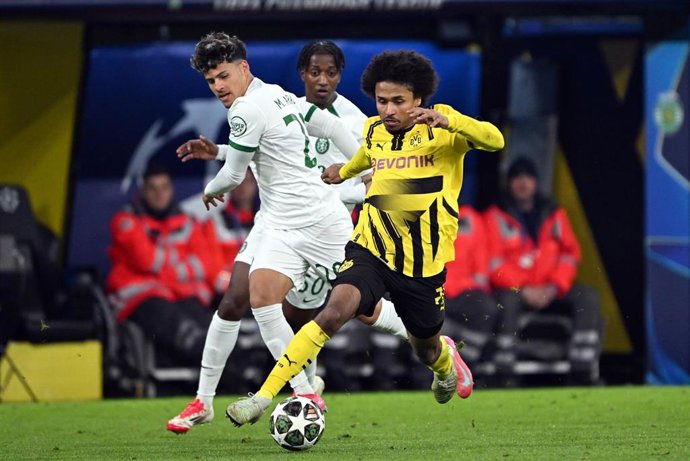 19 February 2025, North Rhine-Westphalia, Dortmund: Dortmund's Karim Adeyemi (R) in action against Sporting's Maximiliano Araujo during the UEFA Champions League layoff second leg soccer match between Borussia Dortmund and Sporting Lisbon at the Signal Id