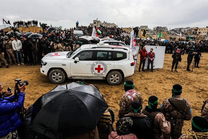 20 de fevereiro de 2025, Territórios Palestinos, Khan Younis: Membros da Cruz Vermelha inspecionam um caixão durante a entrega dos corpos de quatro reféns israelenses pelo Hamas em Khan Yunis. Os restos mortais, que se acredita incluírem membros da famíli