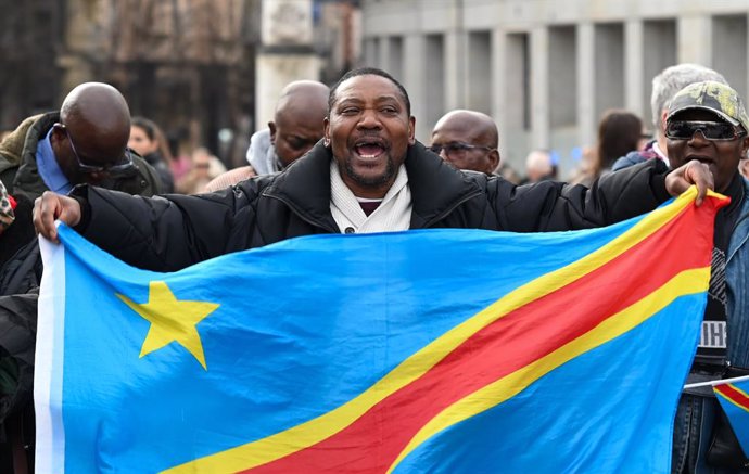 15 February 2025, Spain, Madrid: A protester waves the Democratic Republic of Congo's flag as he takes part in a rally in support of the Democratic Republic of the Congo following the capture of Goma in North Kivu, Democratic Republic of Congo, by the M23