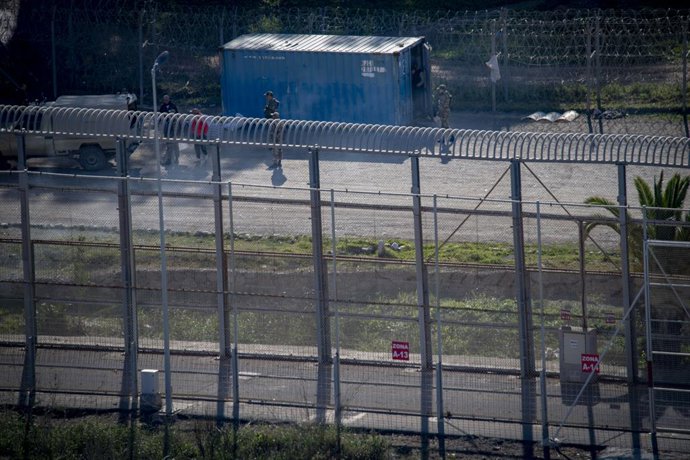 Archivo - Varios migrantes trabajan junto a la valla fronteriza, a 1 de enero de 2025, en Ceuta (España). Con motivo de la noche de fin de año, el gobierno marroquí ha reforzado su presencia en las inmediaciones del perímetro fronterizo de Ceuta con alred