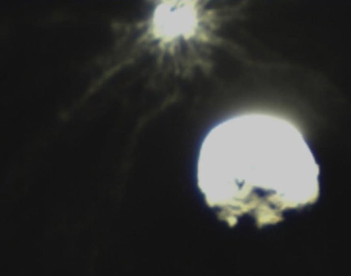 Archivo - Dimorphos aparece arriba expulsando escombros tras el impacto de la nave DART