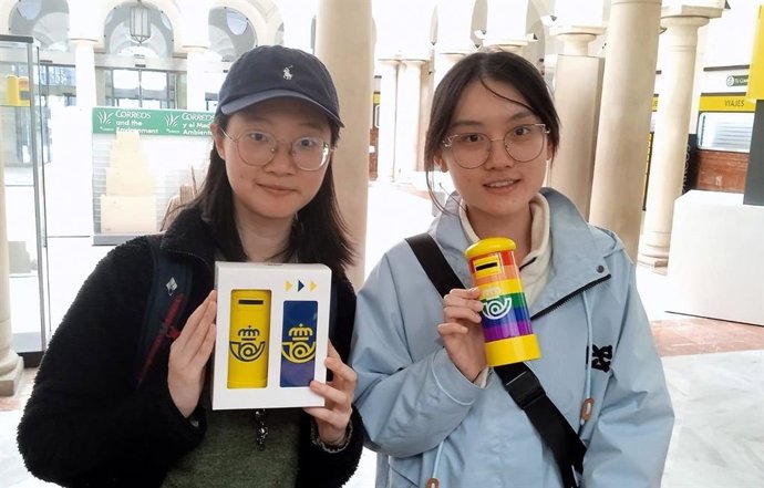 Imagen de turistas asiáticas con las huchas-buzón de Correos.