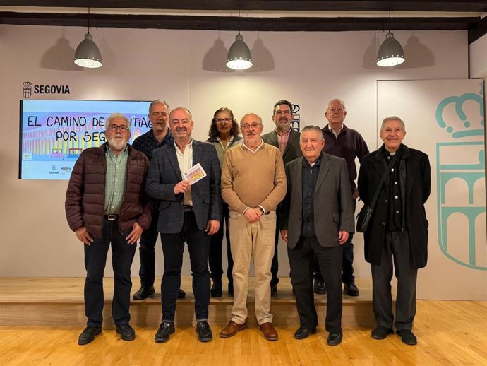 El concejal de Cultura de Segovia, Sergio Calleja, muestra la credencial de peregrino junto a miembros de la Asociación de Amigos del Camino en Segovia.