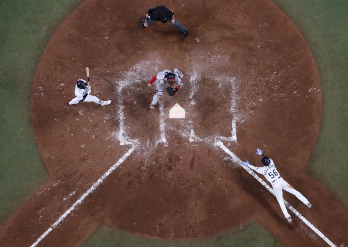 Archivo - 07 October 2021, US, St. Petersburg: Rays' Randy Arozarena (R), slides into home plate as Red Sox catcher Christian Vazquez (C), anticipates the throw while Rays second baseman Brandon Lowe (L), and umpire Dan Bellino watch the play during the s