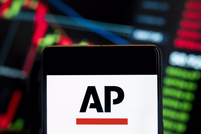 Archivo - June 21, 2024, China: In this photo illustration, the American news agency Associated Press (AP) logo seen displayed on a smartphone with an economic stock exchange index graph in the background.