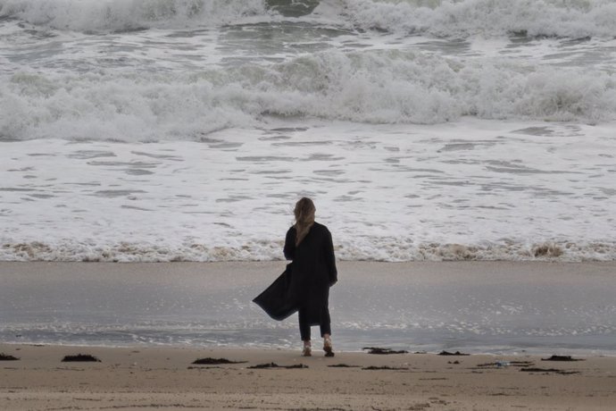 Una mujer en una playa de la comarca de Salnés, a 27 de enero de 2025, en Salnés, Pontevedra, Galicia (España). La borrasca 'Herminia' recorre la Península hoy y llegará hasta el Mediterráneo y Baleares al final del día cuando se producirán los fenómenos 