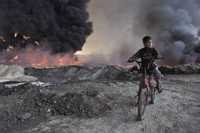 Archivo - October 21, 2016 - Qayyarah, Iraqi-Kurdistan, Iraq - A young boy sits on his bicycle amongst during oil wells in the town of Qayyarah, Iraq. The oil wells, located in a residential neighbourhood on the edge of the town, were part of a large oilf