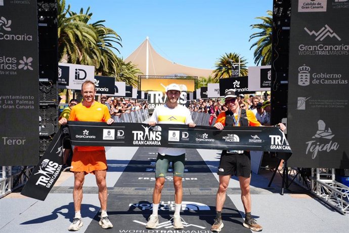 Los tres primeros clasificados de la The North Face Transgrancanaria Classic de 126 kilómetros a su llegada a la meta, en Parque Sur, en Maspalomas (Gran Canaria)