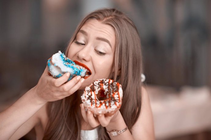 Archivo - Mujer comiendo dulces con ansiedad.