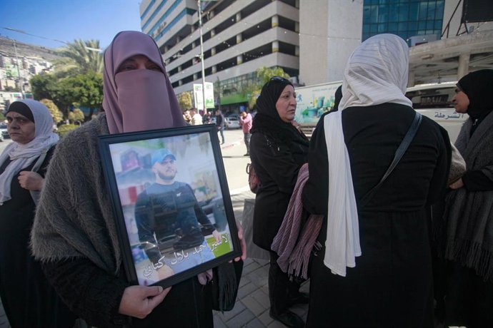 18 de fevereiro de 2025, Nablus, Cisjordânia, Palestina: A mãe de um prisioneiro palestino segura uma foto de seu filho, pedindo um acordo de troca de prisioneiros entre o Hamas e Israel na segunda rodada de negociações entre Israel e o Hamas, durante uma