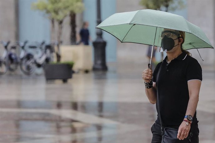 Archivo - Una persona sostiene un paraguas mientras llueve, a 26 de julio de 2021, en Valencia