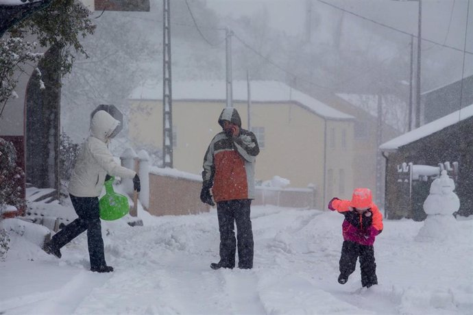 Archivo - Tres personas en una vía nevada. 