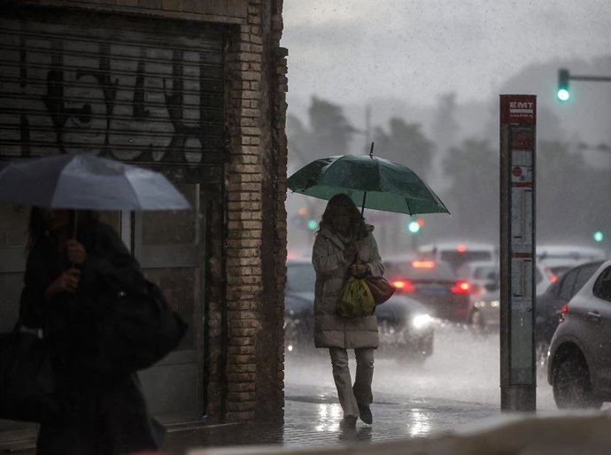 Archivo - Arxiu - Dos dones caminen mentre es protegixen de la pluja amb paraigua, a 11 de novembre del 2022, a València, Comunitat Valenciana (Espanya). 