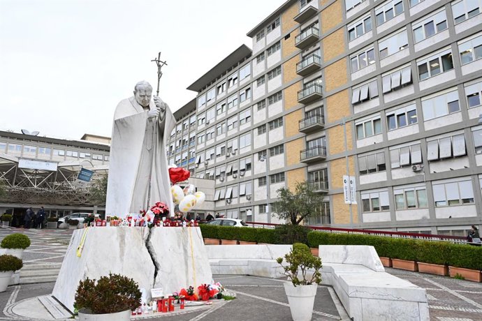 24 de fevereiro de 2025, Roma, ITÁLIA: Velas e balões sob a estátua de João Paulo II do lado de fora do Hospital Agostino Gemelli, onde o Papa Francisco está internado em Roma, Itália, em 24 de fevereiro de 2025. A noite correu bem, o papa Francisco dormi