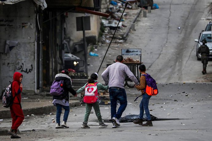Un hombre junto a varios niños en Cisjordania durante una operación militar de Israel