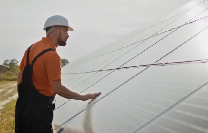 Un operario revisa placas solares.
