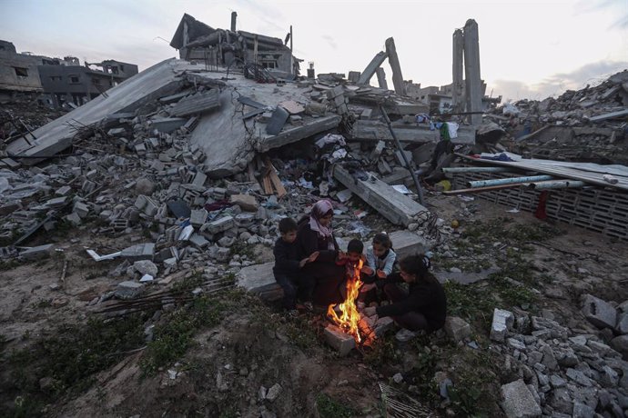 Una madre palestina con sus hijos frente a los escombros de su vivienda en la ciudad de Gaza, destruida por el Ejército de Israel durante su ofensiva contra la Franja de Gaza (archivo)