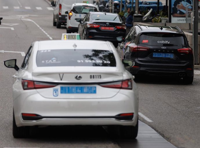 Archivo - Un taxi circulando junto a un VTC, a 8 de junio de 2023, en Madrid (España). 