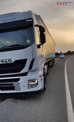 Archivo - Un vehículo de Mossos y un camión, en una imagen de archivo