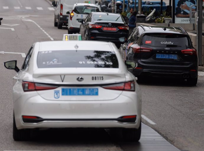 Archivo - Un taxi circulando junto a un VTC, a 8 de junio de 2023, en Madrid (España). 