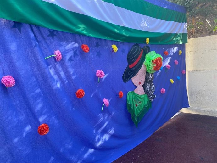 Un tapiz decorado con flores, una figura flamenca y la bandera andaluza ambienta el CEIP Colona Araceli de Almería.