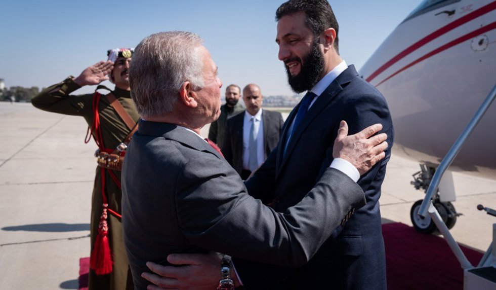 El rey Abdalá II de Jordania (i) recibe en el aeropuerto de Marka, en Amán, al presidente de transición de Siria y líder del grupo yihadista Hayat Tahrir al Sham (HTS), Ahmed al Shara (d)