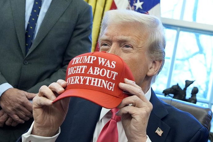 25 de fevereiro de 2025, Washington, Distrito de Columbia, EUA: O presidente dos Estados Unidos, Donald Trump, segura um boné com a inscrição "Trump estava certo sobre tudo" após assinar ordens executivas no Salão Oval da Casa Branca, em Washington, em 23