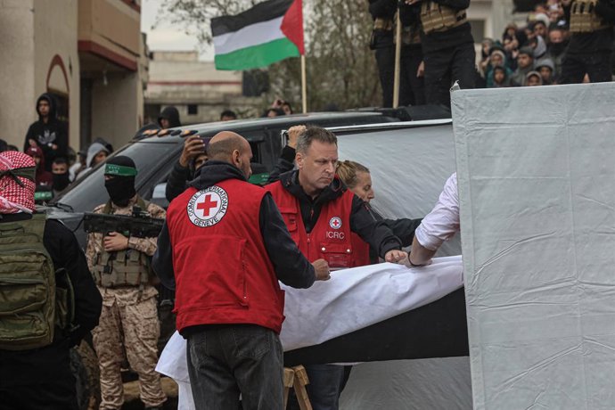 20 de fevereiro de 2025, Khan Yunis, Faixa de Gaza, Território Palestino: Membros das Brigadas Al-Qassam, a ala militar do Hamas, entregam os corpos da família Bibas (três membros) e de Oded Lifshitz às equipes da Cruz Vermelha como parte de uma troca de 