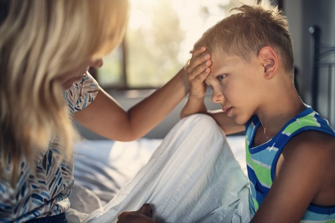 Archivo - Niño con dolor de cabeza junto a su madre