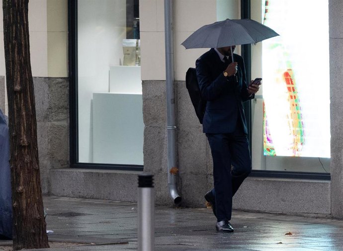 Archivo - Personas con paraguas bajo la lluvia durante la llegada de la borrasca ‘Garoé’, a 20 de enero de 2025, en Madrid (España).