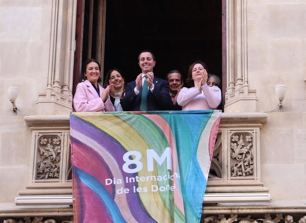 La directora del IbDona, Catalina Salom, el presidente del Consell de Mallorca, Lloren Galmés, y la directora insular de Familias, Ana Ferriol, entre otras autoridades, despliegan la banderola conmemorativa del 8M.