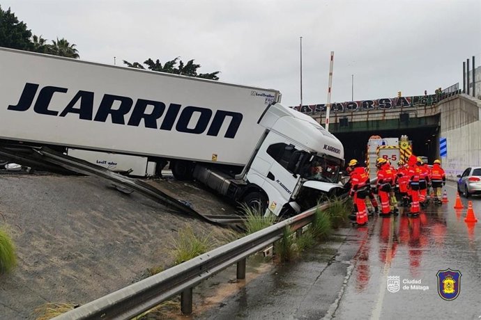 Bomberos de Málaga durante un primer acceso a la zona donde había quedado cruzado el camión que ya se ha retirado de la calzada.