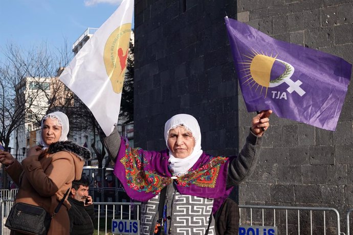 February 27, 2025, Diyarbakir, Turkey: A Kurdish woman is seen waving the flags of the Democratic Regions Party (DBP) and the Free Women's Movement (TJA) as she listens to PKK leader Abdullah Ocalan's call to lay down arms. Abdullah Ocalan, leader of the 